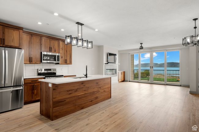 Kitchen with stainless steel appliances, a sink, open floor plan, decorative backsplash, and recessed lighting | Image 5