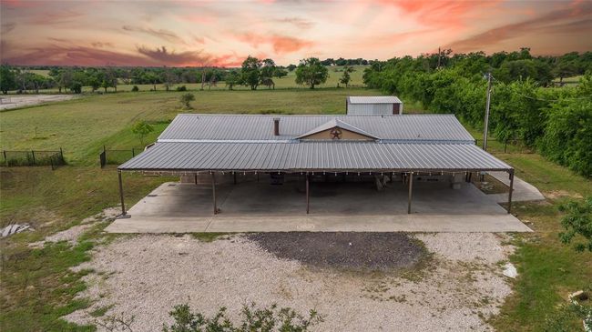 Front house at dusk with an outdoor structure, a rural view, and a lawn | Image 4