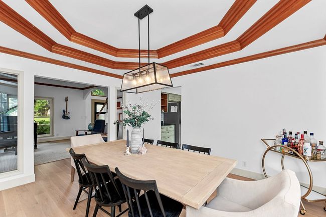 Dining space with a tray ceiling, crown molding, and light wood-style floors | Image 17