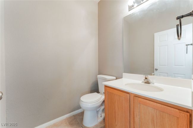 Bathroom with toilet, vanity, tile patterned flooring, and baseboards | Image 37