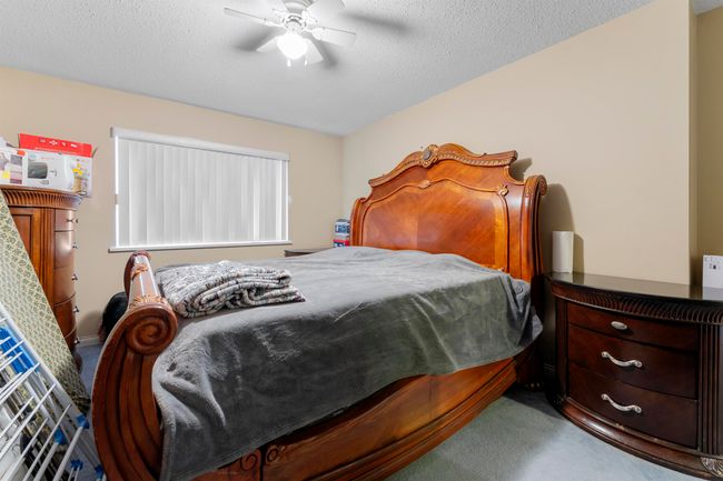 Bedroom with a textured ceiling, carpet floors, and a ceiling fan | Image 16