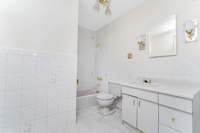 Full bathroom with tile walls, vanity, bathing tub / shower combination, and tile patterned flooring | Image 9
