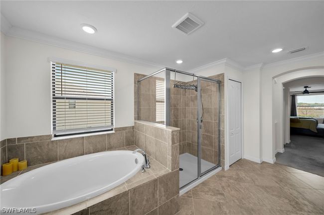 Bathroom with plus walk in shower, ornamental molding, tile patterned flooring, and ceiling fan | Image 44