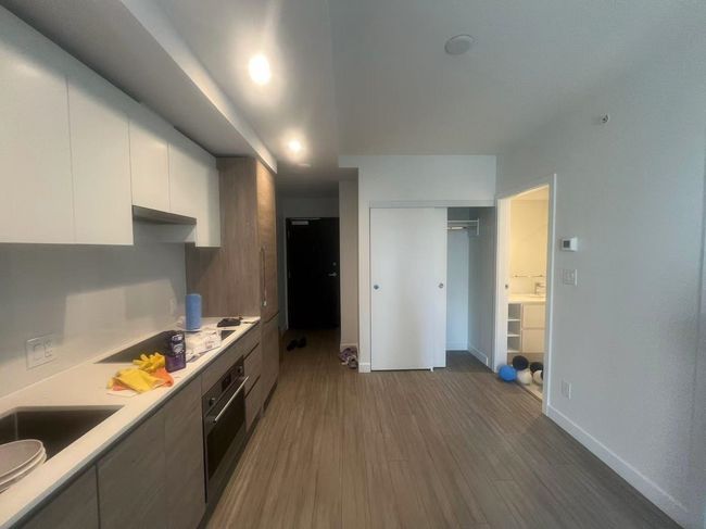 Kitchen with cooktop, oven, white cabinets, light countertops, and dark wood finished floors | Image 13