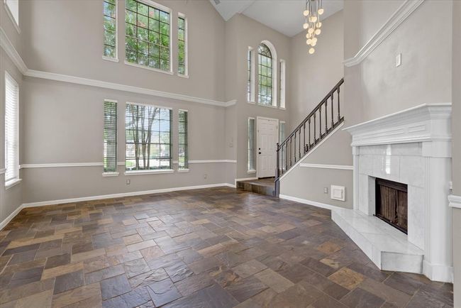 Imagine relaxing with friends and family in the spacious living room with regal high ceilings accentuated with natural light! Gaslog fireplace makes adding to the evening ambiance quick and easy! | Image 4
