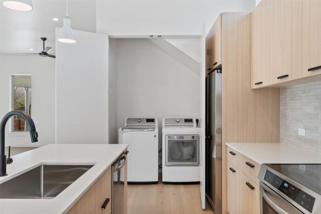 Kitchen featuring a sink, light brown cabinetry, modern cabinets, and washing machine and dryer | Image 10