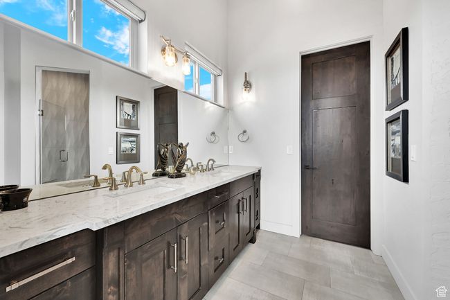 Full bath with double vanity, baseboards, and a shower | Image 31