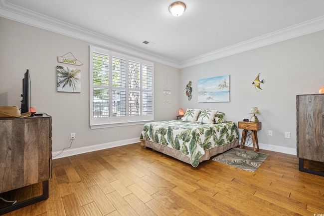 Bedroom with crown molding, wood finished floors, and baseboards | Image 19