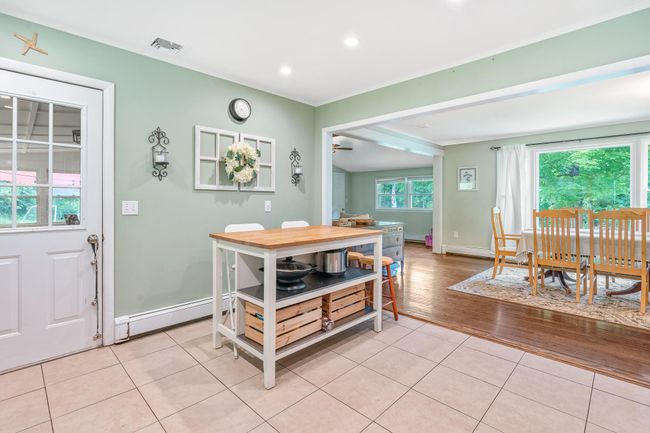 Dining area with ornamental molding, light tile patterned floors, baseboards, a baseboard radiator, and recessed lighting | Image 23
