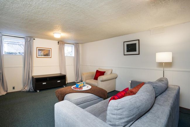Living area with a textured ceiling and carpet | Image 27