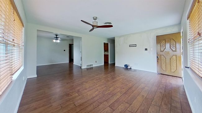 Unfurnished living room with a ceiling fan, dark wood-type flooring, and baseboards | Image 6