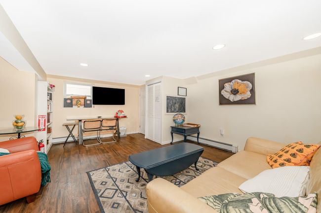 Living room featuring a baseboard heating unit, recessed lighting, wood finished floors, and baseboards | Image 12