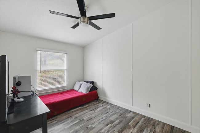 Bedroom with ceiling fan, baseboards, and wood finished floors | Image 21