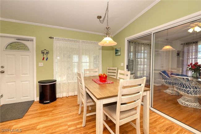 Dining room with lofted ceiling, light wood-type flooring, and crown molding | Image 10
