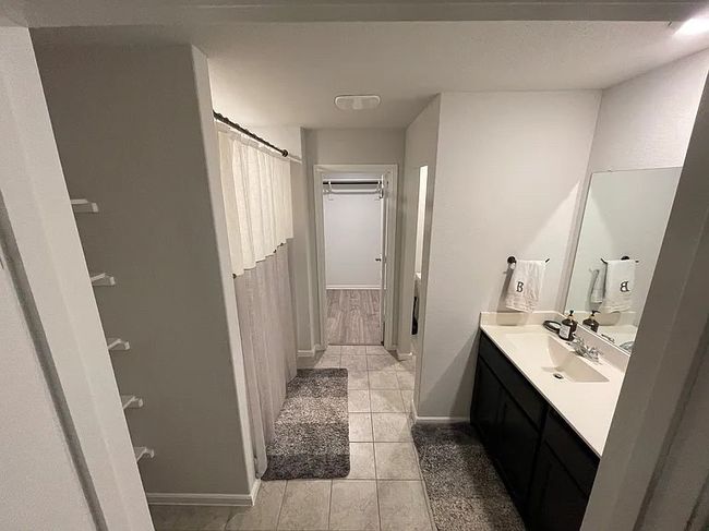 Bathroom featuring baseboards, a shower with curtain, vanity, and tile patterned floors | Image 6