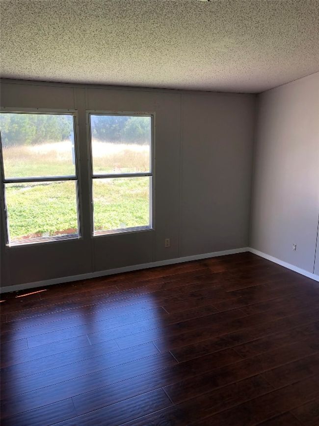 Spare room with dark wood-style flooring and a textured ceiling | Image 4
