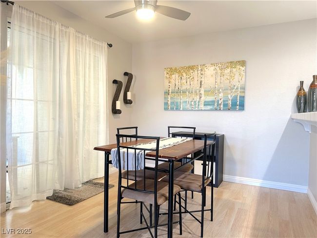 Dining space with ceiling fan, wood finished floors, and baseboards | Image 10