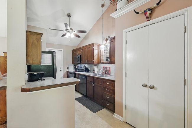 Kitchen with stainless steel appliances, a sink, vaulted ceiling, backsplash, and ceiling fan | Image 16