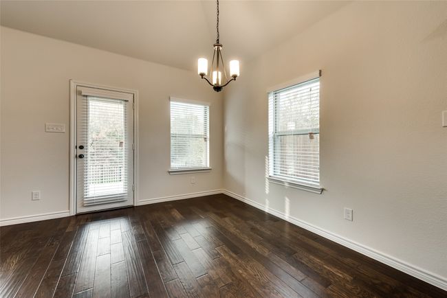 Spare room with a chandelier and dark wood-style flooring | Image 9