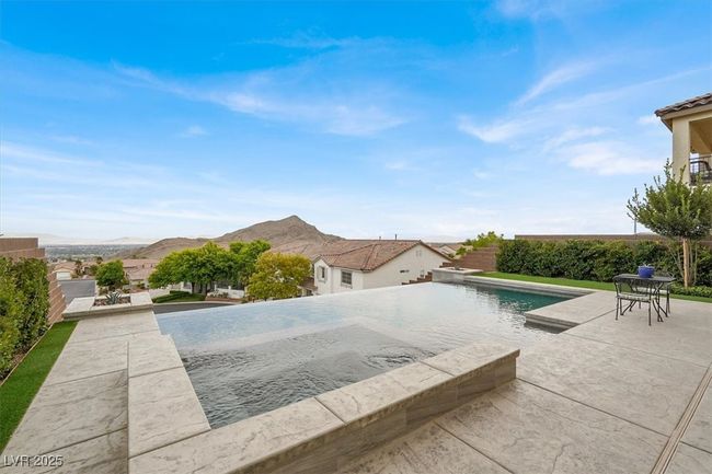 View of pool with a patio area, a mountain view, a hot tub, and an infinity pool | Image 58