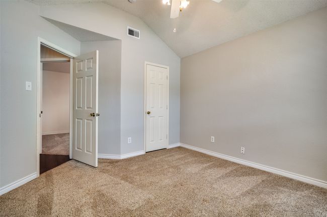 Unfurnished bedroom featuring carpet flooring, lofted ceiling, and ceiling fan | Image 18
