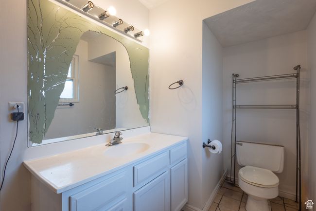 Bathroom with toilet, tile patterned floors, and vanity | Image 12