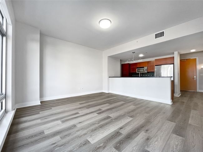 Unfurnished living room featuring light wood-style floors and baseboards | Image 4