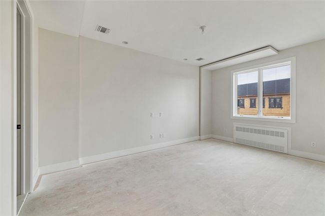 Empty room with baseboards, visible vents, and radiator | Image 30