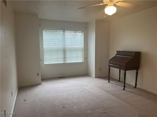 Carpeted Primary Bedroom has large windows and a ceiling fan light. | Image 10
