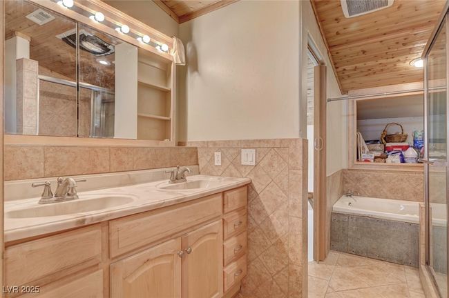Full bath with wood ceiling, tile walls, tile patterned flooring, double vanity, and a garden tub | Image 43