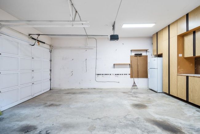 Garage featuring freestanding refrigerator and a garage door opener | Image 30