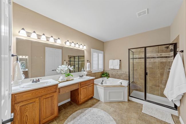Bathroom featuring a bath, a stall shower, double vanity, and tile patterned flooring | Image 23
