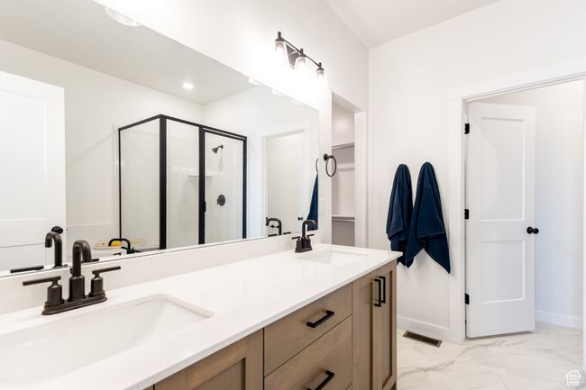 Bathroom with a shower stall, double vanity, marble finish floors, and baseboards | Image 15
