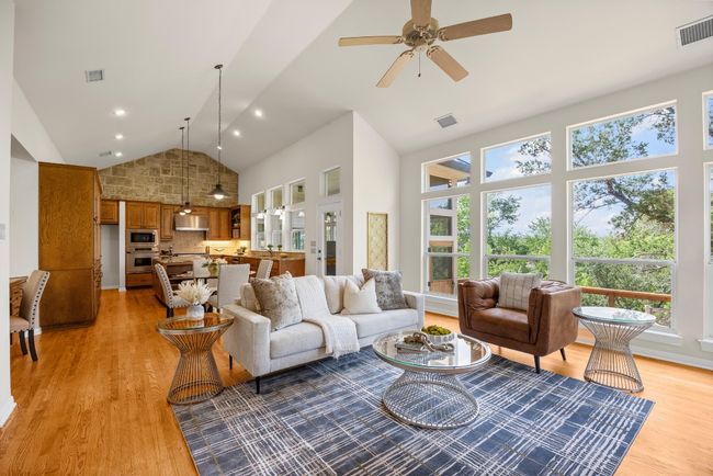 This light-filled great room features a wall of north-facing windows that flood the space with natural sunlight. An open layout seamlessly connects the living area, dining space, and kitchen—perfect for everyday living and entertaining. | Image 6