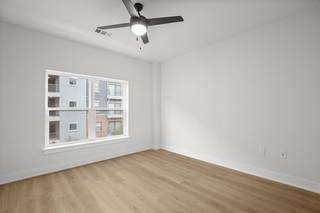 Another photo of bedroom featuring wood finished floors and ceiling fan | Image 13