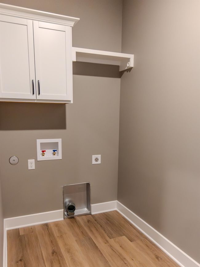 Laundry area featuring light hardwood / wood-style floors, cabinets, hookup for an electric dryer, and washer hookup | Image 11