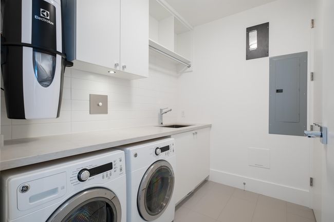 Laundry room featuring electric panel, washing machine and clothes dryer, and cabinet space | Image 26