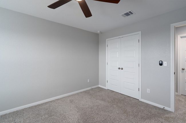 Unfurnished bedroom with carpet, a closet, and a ceiling fan | Image 21