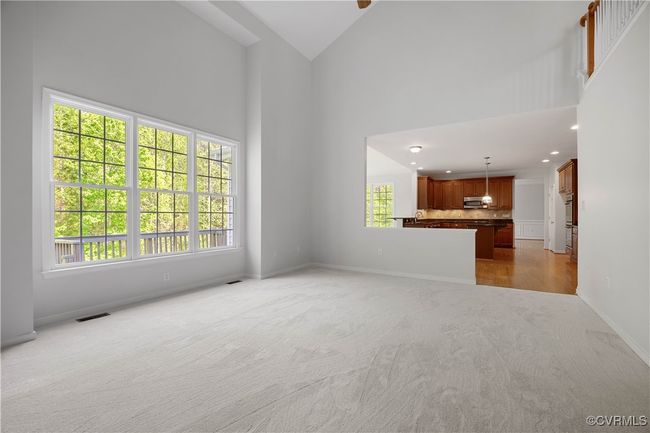 Unfurnished living room featuring visible vents, baseboards, recessed lighting, light carpet, and high vaulted ceiling, with ceiling fan. | Image 21
