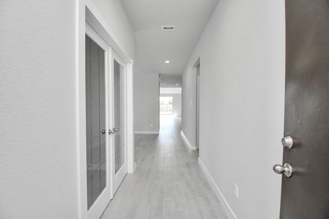 As you step into the threshold of this luxurious home, you'll soon be welcomed by an elegant glass door (to be installed). Inside, soaring ceilings amplify the spaciousness, while the refined wood-look tile flooring and oversized baseboards exude sophistication and charm. | Image 5