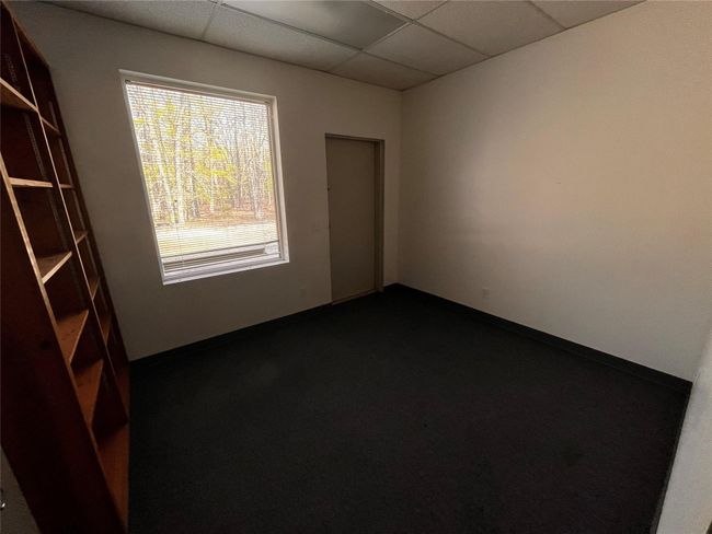 Unfurnished room featuring baseboards, dark carpet, and a drop ceiling | Image 13