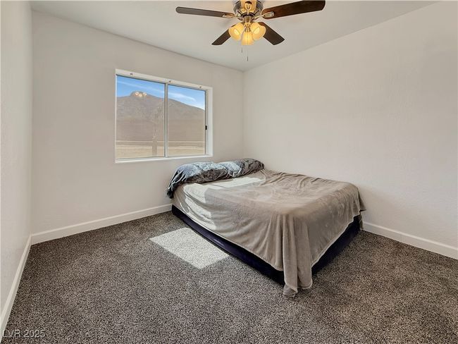 Carpeted bedroom featuring a ceiling fan and baseboards | Image 32