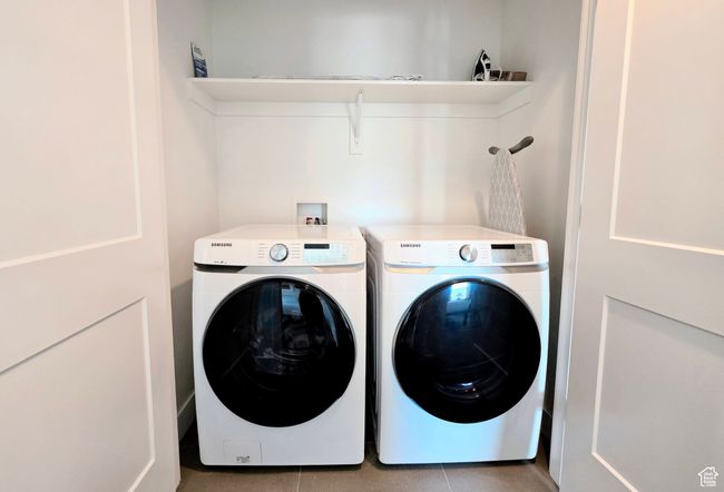 Washroom with washing machine and clothes dryer and light tile patterned flooring | Image 33