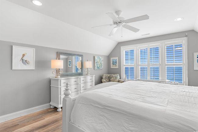Bedroom with baseboards, wood finished floors, vaulted ceiling, recessed lighting, and ceiling fan | Image 25