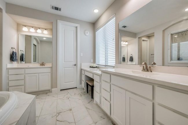 Bathroom featuring marble look tiles, two vanities, a bath, and recessed lighting | Image 16