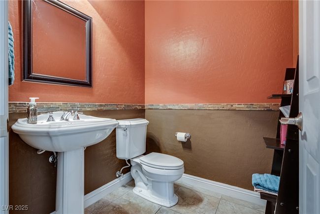 Half bath featuring baseboards, a textured wall, toilet, and tile patterned floors | Image 17