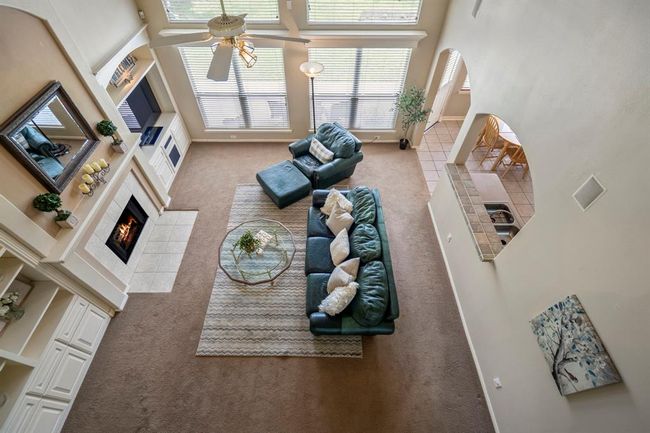 Looking down from above, this view of the living room provides a true sense of the expansive space, showcasing the soaring ceilings and open layout that connects the room to the rest of the home. | Image 25