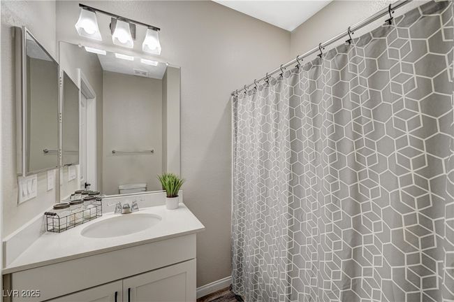 Full bathroom with vanity, toilet, and a shower with shower curtain | Image 32