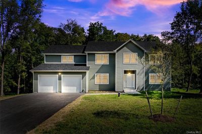 View of front facade featuring a garage and a lawn | Image 1