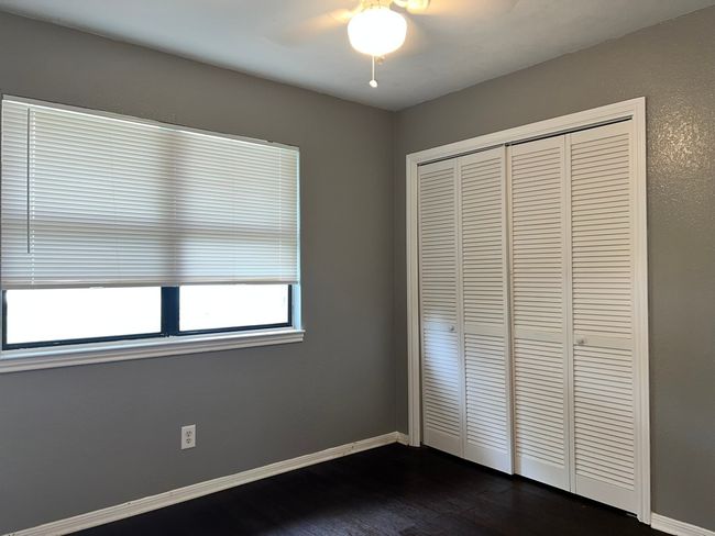 Unfurnished bedroom with dark wood-type flooring, a closet, and ceiling fan | Image 14